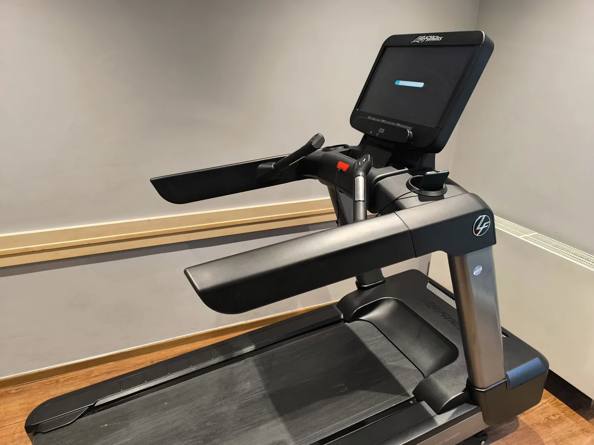Laufband mit aufgeklapptem Bildschirm in einem Trainingsraum – UVV für Sportgeräte: Prüfpflicht, Umfang und Nachweis