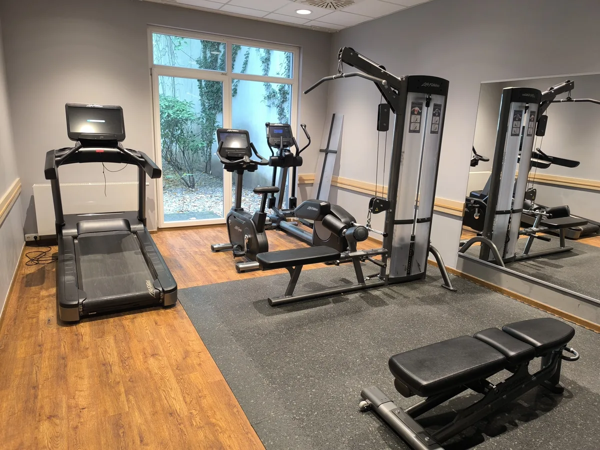 Trainingsraum mit Laufband, Ergometer, Crosstrainer, Kabelzug-Station und Trainingsbänken – Trainingsgeräte in einer Reha-Einrichtung